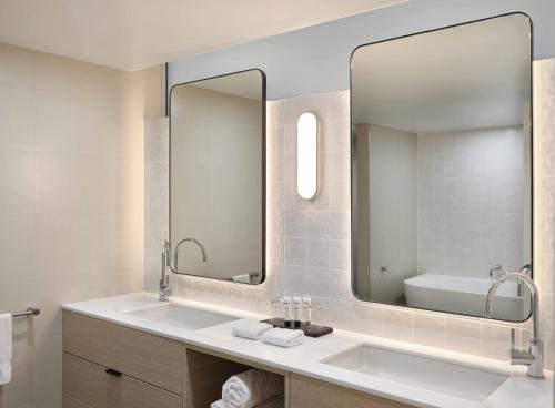 baño con lavabo y espejo grande en Reef View Hotel, en Hamilton Island