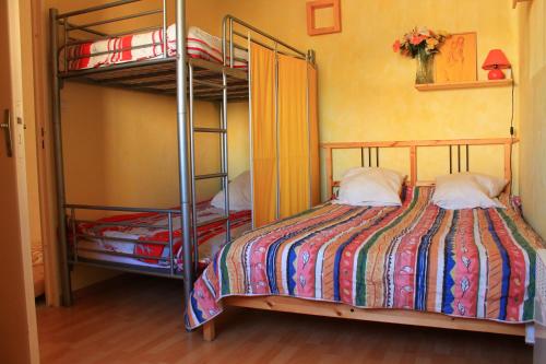a bedroom with two bunk beds in a room at Le Capitole in Narbonne-Plage