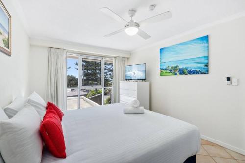 a white bedroom with a large bed and a window at Solnamara - Hosted by Burleigh Letting in Gold Coast