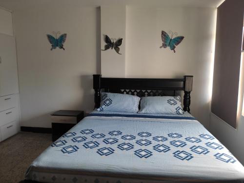 1 dormitorio con 1 cama con mariposas en la pared en Emily place 1 y 2 en San Andrés