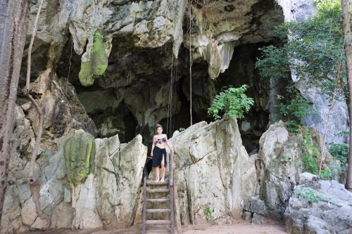 a woman standing on a ladder in a cave at Josefina's Tourist Inn in Busuanga