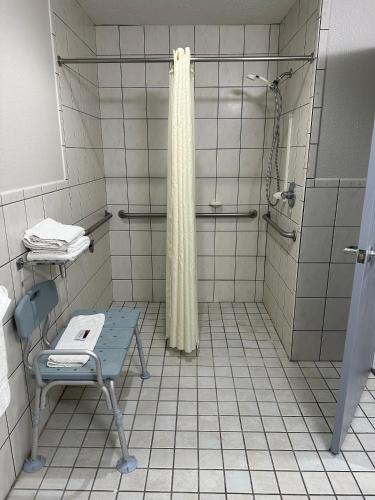 a bathroom with a shower and a bench in it at Baymont by Wyndham Omaha SW in Omaha