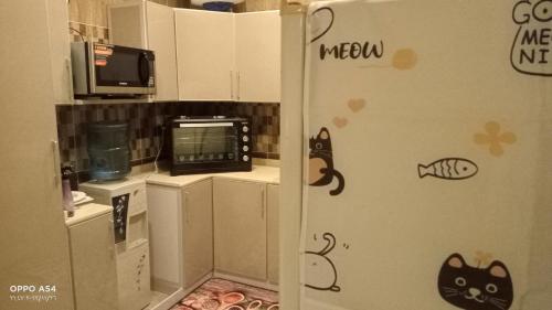 a kitchen with a refrigerator with cats painted on it at anoor appartment,just relaxe in Obhor