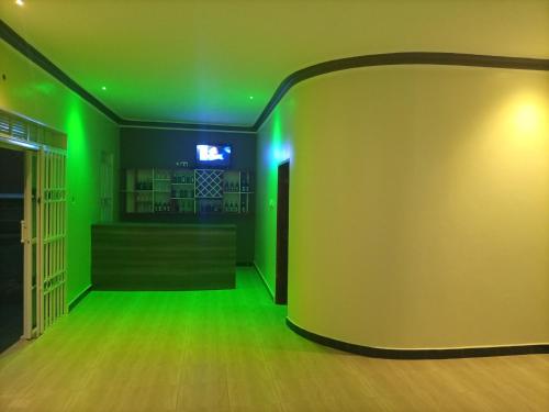 een lege kamer met groene lichten aan de muur bij Pearl Motel Buloba in Buloba