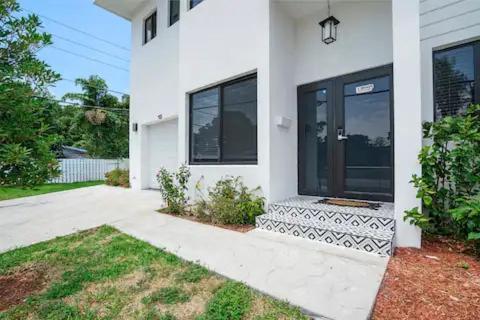 a white house with a window on the side of it at New Townhome near Wilton/Las Olas/Beach in Fort Lauderdale