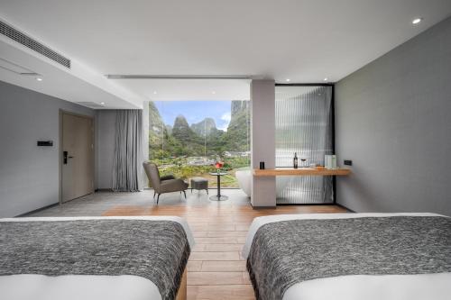 a hotel room with two beds and a tub and a bathroom at Lanshan Moon Resort in Yangshuo