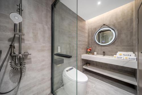 a bathroom with a shower and a toilet and a sink at Lanshan Moon Resort in Yangshuo