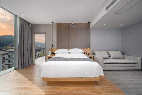 a bedroom with a large white bed and a couch at Lanshan Moon Resort in Yangshuo