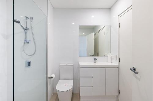a bathroom with a shower and a toilet and a sink at The Shoal 503 Avra Seabreeze in Shoal Bay