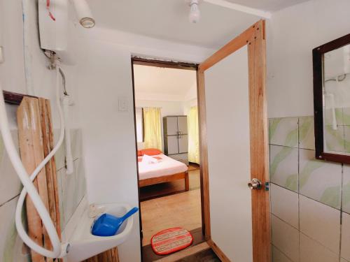 a bathroom with a shower and a door to a bedroom at Patrick's on the Beach Resort in General Luna