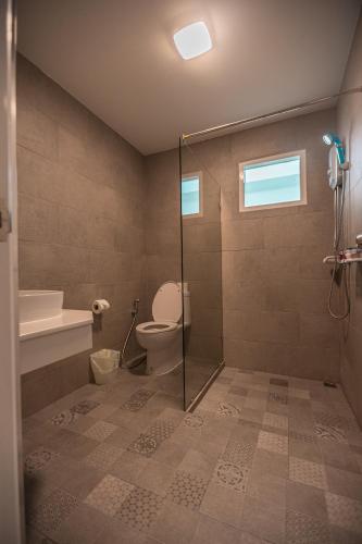 a bathroom with a toilet and a glass shower stall at Tiny Krabi Hotel in Ban Khlong Chi Lat