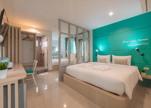 a bedroom with a large bed with a green wall at Tiny Krabi Hotel in Ban Khlong Chi Lat