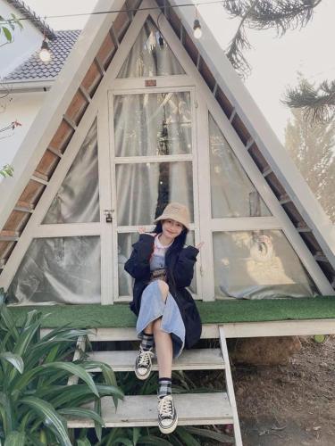 a young girl sitting on a ladder in a doll house at Hoa Son Village Da Lat in Xuan An