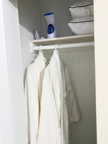 a row of white towels hanging on a shelf at LBC Paradise Bungalow in Long Beach