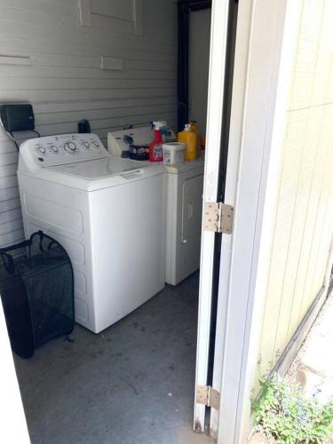 a white washer and dryer sitting in a garage at LBC Paradise Bungalow in Long Beach