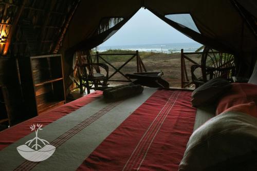 łóżko w namiocie z widokiem na ocean w obiekcie Entremares w mieście Tonalá