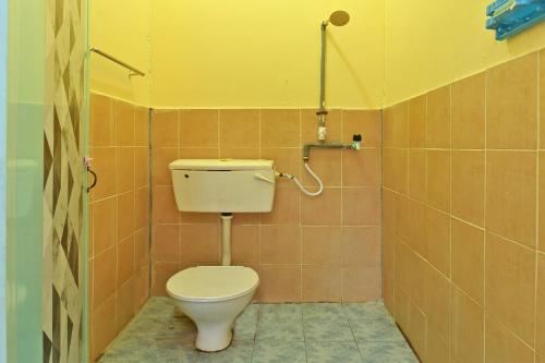 uma casa de banho com WC num quarto em azulejo em OYO 90689 Chalet Kak Siti em Kuala Terengganu