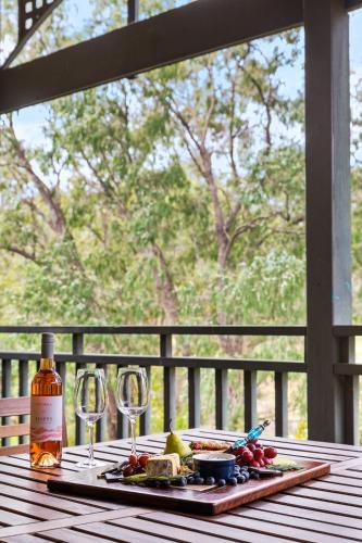a plate of food and wine glasses on a table at Pet Friendly Family Favourite - Kangaroo and Fairway Views with Air Con in Dunsborough