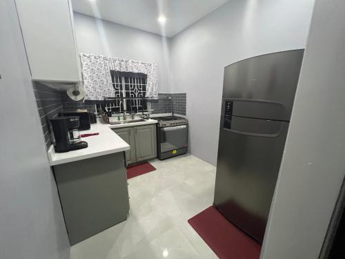 a small kitchen with a refrigerator and a sink at Large Contemporary Two Bedroom in Kingston