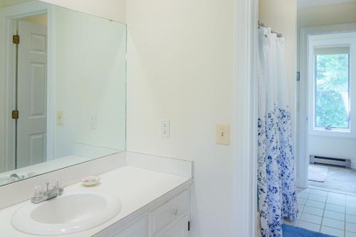 a white bathroom with a sink and a mirror at SaltBox 1B in White River Junction