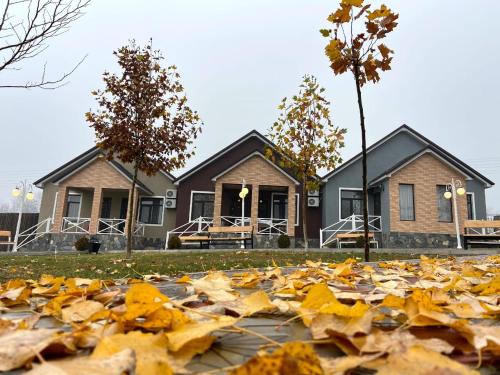 a pile of autumn leaves in front of a house at Tulpan Hotel in Sheki