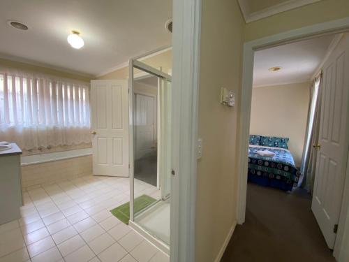 a room with a glass door leading to a bedroom at 4 Beds-Whole House-U2-9 Dennis Street-Reservoir in Melbourne