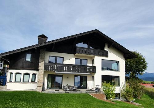 Bergzauber Wohlfühlchalets في بلوسترلانج: منزل أبيض كبير على سقف أسود
