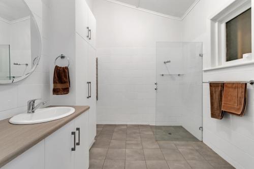 a white bathroom with a sink and a shower at Barefoot Waters in Tailem Bend