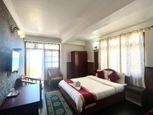 a bedroom with a bed and a desk and a window at The Di-Lac Retreat in Gangtok