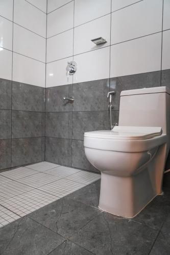 a bathroom with a white toilet and a shower at Aloha Homestay in Varkala