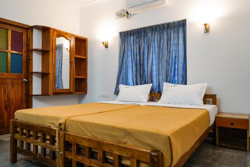 a bedroom with a large bed with a window at Aloha Homestay in Varkala