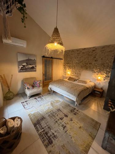 une chambre avec un lit et un lustre dans l'établissement Le Mazet de l'Isle sur la Sorgue, à Saumane-de-Vaucluse