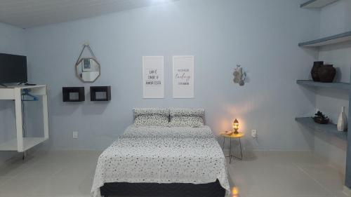 Habitación blanca con cama y lámpara en una mesa en Loft da Lily, en Natal