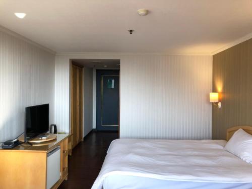 a hotel room with a bed and a television at Hermes Hotel in Hsinchu City