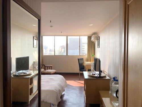 a hotel room with a bed and a desk with a computer at Hermes Hotel in Hsinchu City