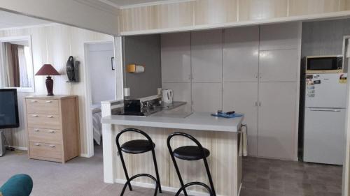 a kitchen with two stools at a kitchen counter at Park View 'Home Away From Home' in Feilding