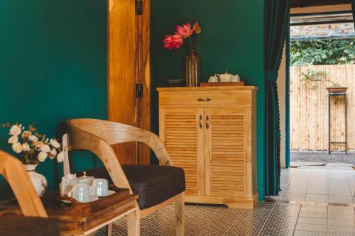 a room with a chair and a wooden cabinet at Orchard Home Nam Cat Tien in Cat Tien
