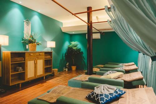 four beds in a room with green walls at Orchard Home Nam Cat Tien in Cat Tien