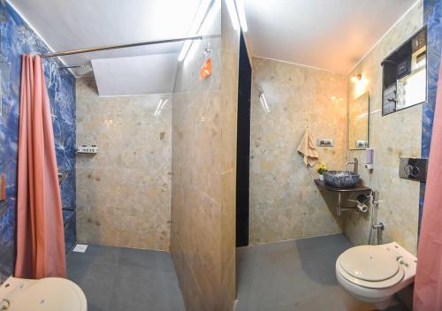 uma casa de banho com um chuveiro e um WC. em Garden Cottage Villa by Tropicana Stays em Lonavala