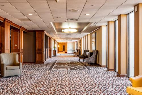 a hallway with chairs and tables in a building at Wyndham Omaha Hotel - West Dodge in Omaha