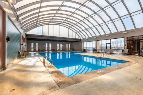 a large swimming pool with a glass ceiling at Wyndham Omaha Hotel - West Dodge in Omaha