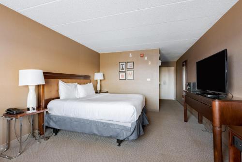 a hotel room with a bed and a flat screen tv at Wyndham Omaha Hotel - West Dodge in Omaha