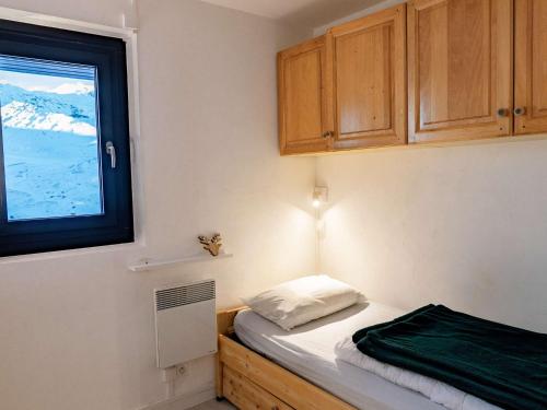 une petite chambre avec un lit et une fenêtre dans l'établissement Charmant 2 Pièces Rénové Val Thorens - 4 Pers, Ski aux Pieds, Balcon, Wi-Fi - FR-1-637-23, à Val Thorens