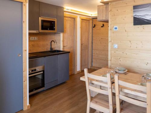 - une cuisine avec une table, une cuisinière et un évier dans l'établissement Appartement moderne à Val Thorens - 4 pers - 1 chambre, 1 cabine, skis aux pieds, balcon - FR-1-637-30, à Val Thorens