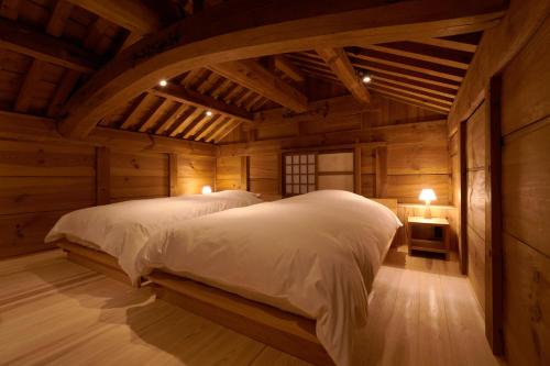 1 dormitorio con 2 camas en una cabaña de madera en RITA Izumo Hirata, en Izumo
