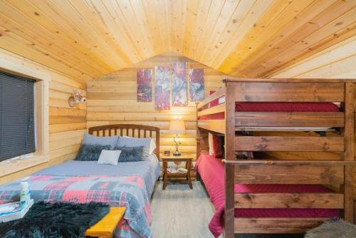 1 dormitorio con 1 cama en una cabaña de madera en 1 Bd Deluxe Log Cabin View Northern Lights en Fairbanks