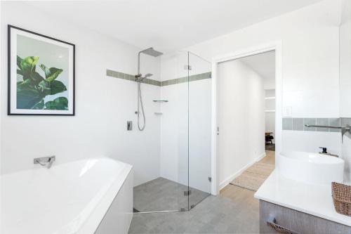a white bathroom with a shower and a sink at Ilanga Jervis Bay-Heated Pool in Huskisson