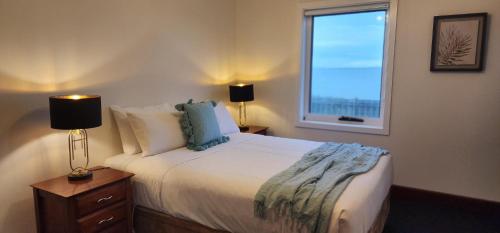 a bedroom with a large bed with a window at Stanley Village Waterfront Accommodation in Stanley