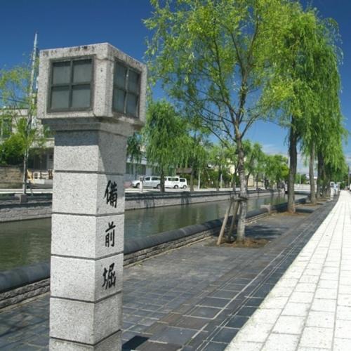 a stone pillar with chinese writing on it next to a river at Mito Sannomaru Hotel in Mito