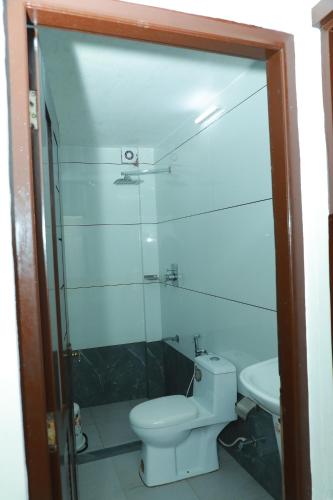 a bathroom with a toilet and a glass shower at Relax Beach Inn in Cherai Beach